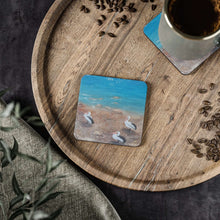 Load image into Gallery viewer, Corkwood underside, glossy finish on top. 1 or 4 pc sets. 9.5 x 9.5cm. Three Australian pelicans on a river bank