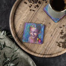 Load image into Gallery viewer, Corkwood underside, glossy finish on top. 1 or 4 pc sets. 9.5 x 9.5cm. Laughing female w/ paint splashes on her. LGBTQIA+