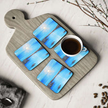 Load image into Gallery viewer, Corkwood underside, glossy finish on top. 1 or 4 pc sets. 9.5 x 9.5cm. Blue sea at sunset / sunrise