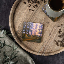 Load image into Gallery viewer, Corkwood underside, glossy finish on top. 1 or 4 pc sets. 9.5 x 9.5cm. Sunset scene in a pine forest, Sun rays & colours