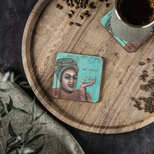 Load image into Gallery viewer, Corkwood underside, glossy finish on top. 1 or 4 pc sets. 9.5 x 9.5cm. Female portrait & words "What is free to me- No fear!"