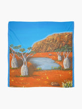 Load image into Gallery viewer, Large rock formation, boab trees, billabong & emu, Beautiful orange & blue complimentary colours 140x140cm scarf/wrap/shawl