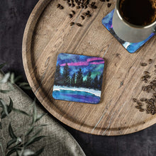 Load image into Gallery viewer, Corkwood underside, glossy finish on top. Available in 1 or 4 pc sets. 9.5 x 9.5cm. Northern lights, Aurora Borealis, snow
