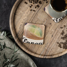 Load image into Gallery viewer, Corkwood underside, glossy finish on top. 1 or 4 pc sets. 9.5 x 9.5cm. Lime slice in a frothy beer bottle with bubble rising
