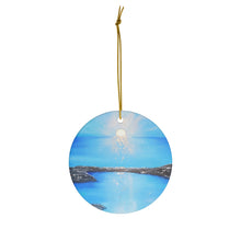 Load image into Gallery viewer, Original painting of a silver leaf sunset over blue water on a round ceramic ornament with hanging string
