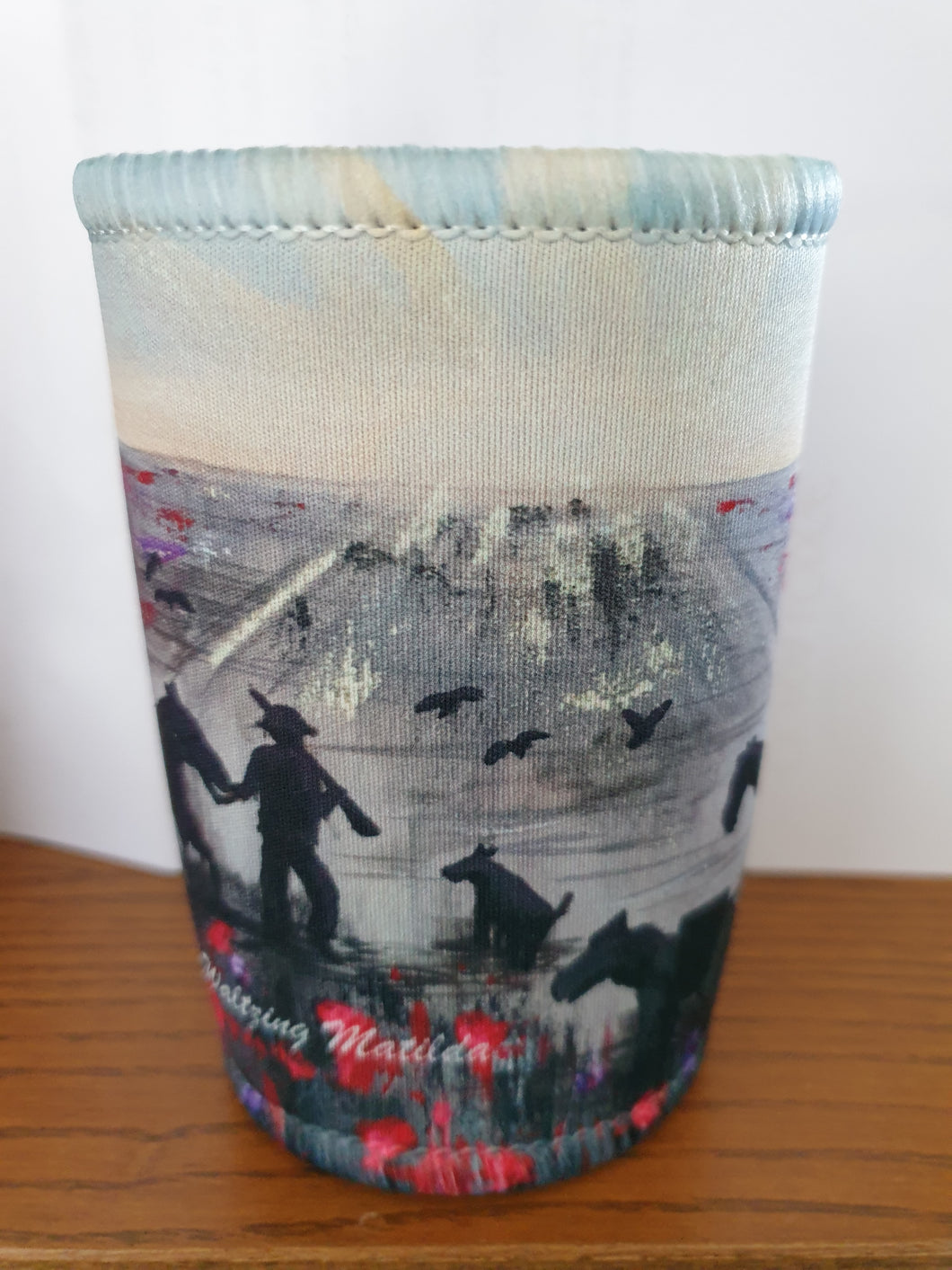 Original painting of a soldier, horse, camel, donkey, dog and birds walking towards an ANZAC Crest inspired sunrise through a field of poppies on a double stitched excellent quality stubby holder / cooler