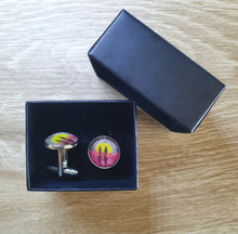 Load image into Gallery viewer, Original painting of a rising sun which is an abstract version of the Aboriginal flag with the silhouette of an Aboriginal holding a spear and a soldier holding a gun surrounded by red poppies on 16mm platinum cufflinks
