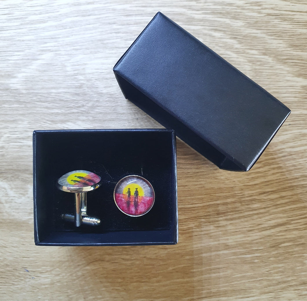 Original painting of a rising sun which is an abstract version of the Aboriginal flag with the silhouette of an Aboriginal holding a spear and a soldier holding a gun surrounded by red poppies on 16mm platinum cufflinks