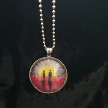 Load image into Gallery viewer, Original painting of a rising sun which is an abstract version of the Aboriginal flag with the silhouette of an Aboriginal holding a spear and a soldier holding a gun surrounded by red poppies on a 30mm silver coloured round pendant with a 60cm ball chain

