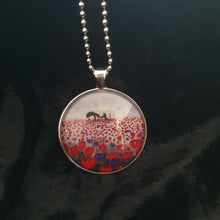 Load image into Gallery viewer, original artwork of a sunrise (in the form of the ANZAC Crest) with a silhouette of a soldier kneeling next to his horse drinking from his hat in a field of red and purple poppies on a 38mm silver coloured round pendant with a 60cm ball chain
