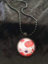 Load image into Gallery viewer, Original painting of red poppies with an abstract background on a black coloured 25mm round pendant with a 60cm ball chain
