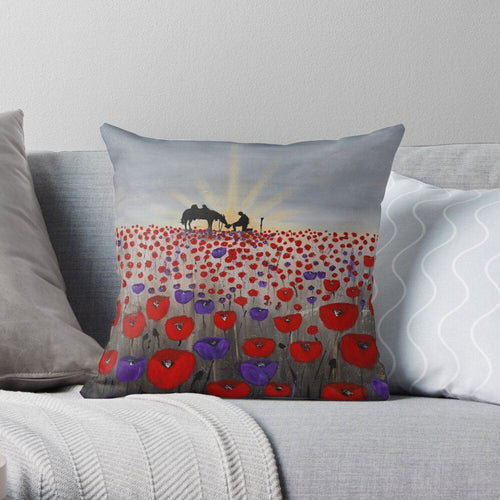 original artwork of a sunrise (in the form of the ANZAC Crest) with a silhouette of a soldier kneeling next to his horse drinking from his hat in a field of red and purple poppies on a 40 x 40cm cushion cover