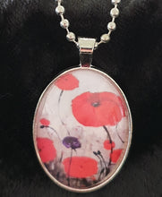 Load image into Gallery viewer, Original painting of red poppies with an abstract background on a silver coloured 25 x 30mm oval pendant with a 60cm ball chain
