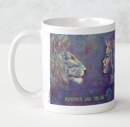 Original bold colour painting of a lion and a lady looking at each other  with the words Remember Who You Are at the bottom on a ceramic mug