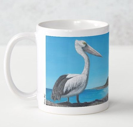 Original painting of an Australian pelican standing rocks overlooking a beach on a ceramic mug